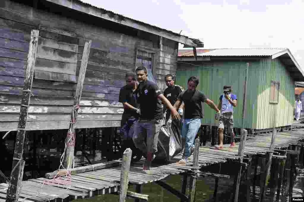 Warga desa membawa jenazah penembak yang tewas pada Sabtu (2/3) di desa Simunul, distrik Semporna, negara bagian Sabah (4/3). 