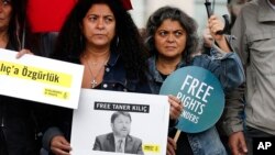 Human rights activists stage a protest outside a court where eleven human rights activists, among them Amnesty International's Turkey chairman Taner Kilic, are on trial, accused of belonging to and aiding terror groups, in Istanbul, Turkey, Oct. 25, 2017.