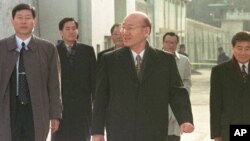 FILE - Former South Korean President Chun Doo Hwan, center, leaves the Anyang Prison with his aides following his release from prison in a special amnesty, Dec. 22, 1997. 