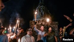 FILE - White nationalists participate in a torch-lit march on the grounds of the University of Virginia ahead of the Unite the Right Rally in Charlottesville, Virginia, on Aug. 11, 2017. 