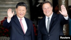 China's President Xi Jinping and his Panamanian counterpart Juan Carlos Varela wave to journalists before a private meeting as part of Xi's first state visit to Panama, at Presidential Palace in Panama City, Panama, Dec. 3, 2018. 