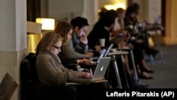 In this photo taken Wednesday, April 3, 2013, people work on their computers at the British Library in London.