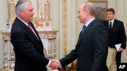 FILE - Vladimir Putin (R), then Russia's prime minister, shakes hands with Rex Tillerson, chairman and chief executive officer of Exxon Mobil Corporation, at their meeting at the Novo-Ogaryovo residence outside Moscow, April 16, 2012.