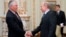 FILE - Vladimir Putin (R), then Russia's prime minister, shakes hands with Rex Tillerson, chairman and chief executive officer of Exxon Mobil Corporation, at their meeting at the Novo-Ogaryovo residence outside Moscow, April 16, 2012.