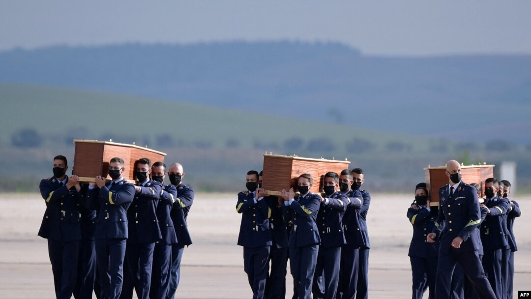 Spanish air force personnel carry the coffins with the bodies of Spanish journalists David Beriain and Roberto Fraile and Irish ONG chief Rory Young, killed in eastern Burkina Faso, after arriving in the Torrejon de Ardoz air base on April 30, 2021. 