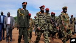 FILE - South Sudan's President Salva Kiir, center, and newly appointed army chief of staff Lt. Gen. James Ajongo Mawut, right, attend a ceremony marking the 34th anniversary of the Sudan People's Liberation Army in Juba, South Sudan, May 18, 2017..