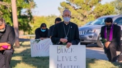 En esta imagen proveída por la Diócesis de El Paso, el obispo Mark Seitz, ora arrodillado durante una protesta por la muerte de George Floyd en Minneapolis.
