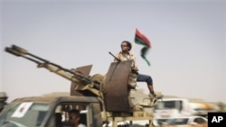 Rebels reinforcements from Tripoli goes through a checkpoint between Tarhouna and Bani Walid, towards the front in Bani Walid, Libya, Monday, Sept. 5, 2011.