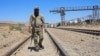 A Taliban security official walks at the construction site of railway tracks during the inauguration ceremony of the TAPI pipeline project, at the Turghundi border post in Kushk district of Herat province in Afghanistan on Sept. 11, 2024.