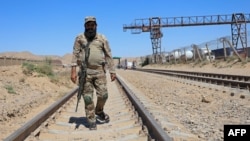 A Taliban security official walks at the construction site of railway tracks during the inauguration ceremony of the TAPI pipeline project, at the Turghundi border post in Kushk district of Herat province in Afghanistan on Sept. 11, 2024.