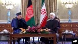 Iran's President Hassan Rouhani (R) speaks with Afghan President Hamid Karzai during their meeting at Tehran's Saadabad Palace Dec. 8, 2013.