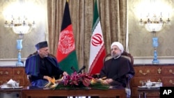 Presiden Iran Hassan Rouhani (kanan) bertemu dengan Presiden Hamid Karzai di Istana Saadabad di Teheran, Minggu (8/12).