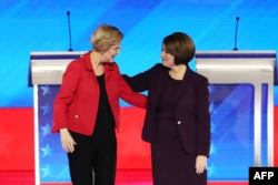 Democratic presidential candidates Sen. Elizabeth Warren (D-MA), left, and Sen. Amy Klobuchar (D-MN) greet each before the start of the Democratic presidential primary debate, Feb. 7, 2020, in Manchester, N.H.