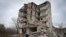FILE— Local resident Yevhen, 34, looks at his home in an apartment house damaged in 2022 heavy battles with the Russian troops in Izium, Kharkiv region, Ukraine, March 17, 2024. 