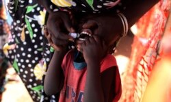 FILE - A child receives an oral cholera vaccine in a camp for internally displaced people in the United Nations Mission in South Sudan (UNMISS) compound in Tomping, Juba, Feb. 28, 2014.