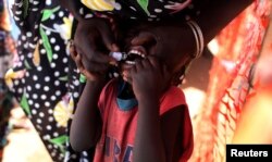 FILE - A child receives an oral cholera vaccine in a camp for internally displaced people in the United Nations Mission in South Sudan (UNMISS) compound in Tomping, Juba, Feb. 28, 2014.