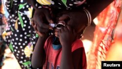 A displaced South Sudanese child receives an oral cholera vaccine in a camp for internally displaced people in the United Nations Mission in South Sudan (UNMISS) compound in Tomping, Juba February 28, 2014