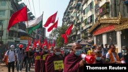 Buddhist monks and demonstrators rally against the military coup and to show their support to local residents after riot police officers used teargas to disperse a crowd that held a protest the night before in Yangon's Tamwe neighborhood