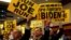 Supporters hold signs as former Vice President Joe Biden addresses the International Association of Fire Fighters in Washington, March 12, 2019.