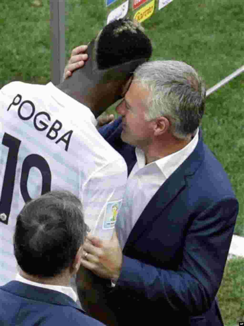 France's Paul Pogba, left, is congratulated by head coach Didier Deschamps after the World Cup round of 16 soccer match between France and Nigeria at the Estadio Nacional in Brasilia, Brazil, Monday, June 30, 2014. France won 2-0 and advances to the quart