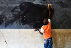 FILE - A young boy cleans the blackboard at a school in Segou, Mali, Oct 1, 2019.