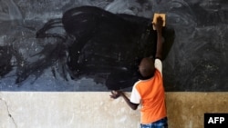 FILE - A young boy cleans the blackboard at a school in Segou, Mali, Oct 1, 2019. A United Nations study says 222 million students worldwide have had their education disrupted by recent crises.