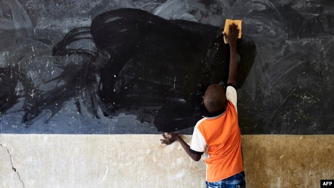 FILE - A young boy cleans the blackboard at a school in Segou, Mali, Oct 1, 2019. A United Nations study says 222 million students worldwide have had their education disrupted by recent crises.