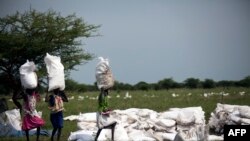 Des femmes portent des sacs de nourriture distribués par Oxfam à Padding, dans le Soudan du Sud, le 3 juillet 2017.