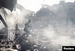 Warga Palestina di lokasi serangan Israel di sebuah bangunan tempat tinggal, di tengah konflik yang sedang berlangsung antara Israel dan Hamas, di Khan Younis di selatan Jalur Gaza, 7 November 2023. (Foto: REUTERS/Mohammed Salem)