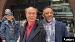 Massachusetts resident Litang Liang, left, and his lawyer, Derege Demissie, stand outside the federal court after a jury acquitted Liang of U.S. charges that he acted as an unregistered agent of China, in Boston, Feb. 10, 2025. 