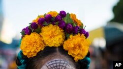 Marla Fernandez, 12, poses for a picture before the start of a Day of the Dead parade in Juchitan, Mexico, Oct. 31, 2018. 