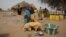 Maryam Sy comforts her 2-year-old son Aliou Seyni Diallo, the youngest of nine, after a neighbor gave him dry couscous to stop him from crying with hunger, May 1, 2012. 