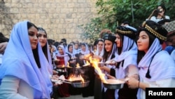 
Des Yézidis iraquiens allument des bougies et des lampes à pétrole lors d'une cérémonie célébrant le nouvel an yézidi au temple Lalish de Shikhan dans la province de Dohuk (Irak), le 17 avril 2018.
