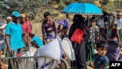 Rohingya refugees gather to collect relief materials from a distribution point in the Kutupalong Refugee Camp in Ukhia in Bangladesh's Cox's Bazar district on March 6, 2025.