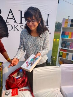 Undergraduate student Divya Gulati buys a book on lesbian stories in India at the festival. (Anjana Pasricha/VOA)