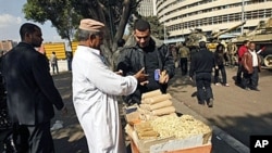 An Egyptian man sells popcorn to people walking outside the national TV building in Cairo three days after Egyptian President Hosni Mubarak stepped down, February 14, 2011