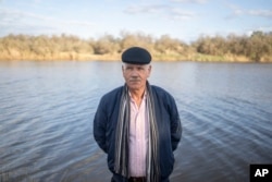Mimoun Nadori poses for a portrait in front of the Moulouya River, in Nador, Morocco. Less rainfall and more damming and pumping upstream has left less water flowing through the river and threatened the livelihoods of farmers like Nadori. (AP Photo/Mosa'ab Elshamy)