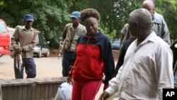 FILE: Zimbabwean human rights activist, Jestina Mukoko, center, is led into court in Harare, Zimbabwe Wednesday, Dec. 24, 2008. State media report that Mukoko, who went missing three weeks ago, is accused of attempting to recruit government opponents for military training to overthrow President Robert Mugabe. (AP Photo)