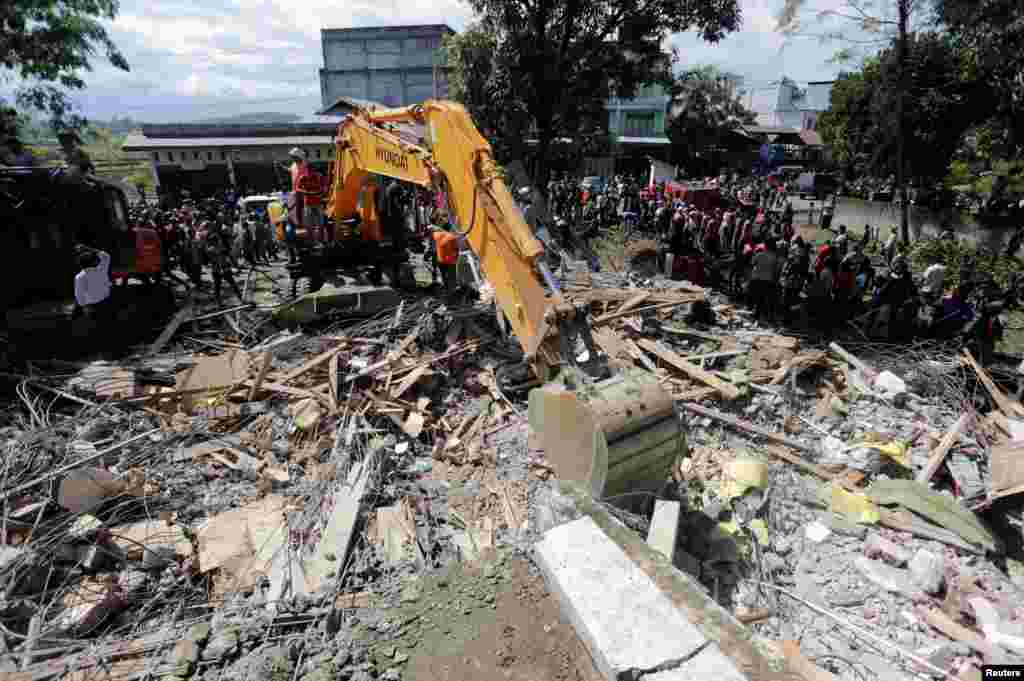جستجوی قربانیان زلزله&zwnj; در یک ساختمان فروریخته در استان آچه در اندونزی.