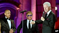 Mantan Presiden AS Bill Clinton (kanan) memberikan sambutan di acara penggalangan dana untuk AIDS "Life Ball", didampingi penyelenggara acara - Gery Keszler (kiri), dan musisi Inggris Elton John selaku penggagas acara tahunan ini di Wina, Austria (25/5).