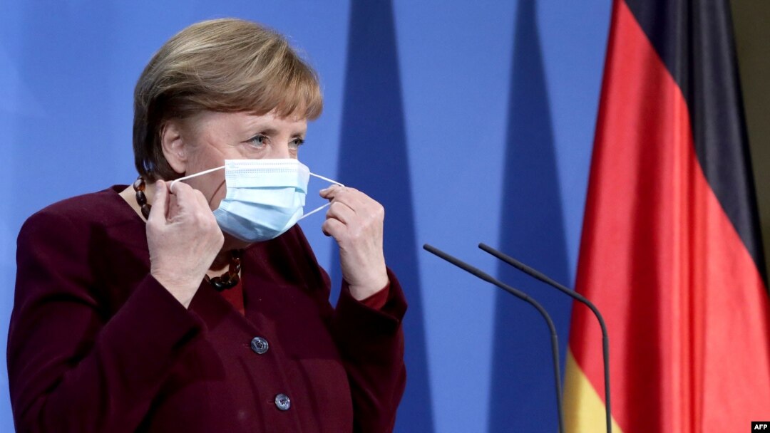 German Chancellor Angela Merkel takes her face mask off as she arrives to a press conference at the chancellery in Berlin, Germany, on March 19, 2021.