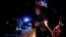 FILE - People light candles as they pay tribute to the 27 migrants who died when their dinghy deflated as they attempted to cross the English Channel, at the Richelieu Park in Dunkerque, France, Nov. 25, 2021. 