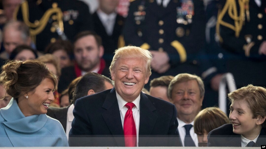 Predsendik Donald Tramp osmehuje se zajedno sa prvom damom Melanijom Tramp dok pratre inauguracionu paradu u Pensilvanija Aveniji ispred Bele kuće u Vašingtonu, 20. januara 2017. (AP Photo/Andrew Harnik)