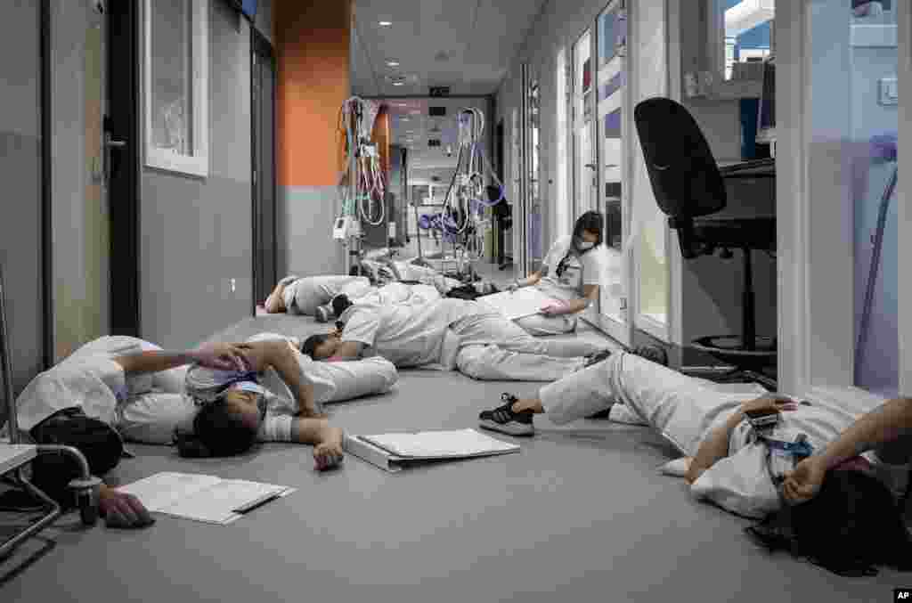 Nurses lay on the floor in the ICU unit during a demonstration on International Nursing and Care day, at the Mont Legia Hospital in Liege, Belgium.
