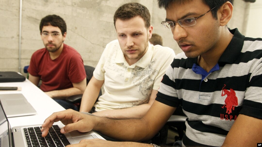 Shiva Gopalan, an international and computer engineering master's student at Texas A&M University (far right), confers with IBM developers Henrique Copelli Zambon (center) and Luiz Aoqui, during an IBM hosted Spark Hackathon at Galvanize, a tech hub in San Francisco on Sunday, June 14, 2015. (George Nikitin/Feature Photo Service for IBM)
