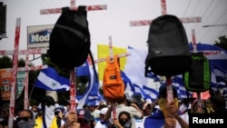 Demonstrators hold up crosses with backpacks during a march to demand the resignation of Nicaragua's President Daniel Ortega in Managua, Nicaragua, July 23, 2018.