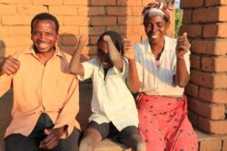 Talandira jokes around with his parents. (Lameck Masina/VOA)