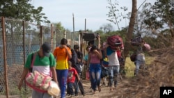 FILE - Venezuelans illegally cross into Colombia, to Villa del Rosario, along a path known as a "trocha," Aug. 31, 2018. 