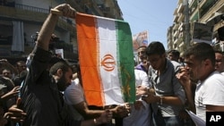 Protesters burn an Iranian flag during a protest organized by Lebanese and Syrians living in Lebanon, to express solidarity with Syria's anti-government protesters, as they march in Tripoli, northern Lebanon. The protesters are opposed to Iran, which has 