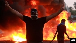 An anti-government protester flashes the victory sign during a demonstration in Baghdad, Iraq, Oct. 3, 2019. 